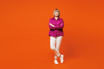 Full body elderly happy blonde woman 50s years old she wear purple shirt casual clothes hold hand...