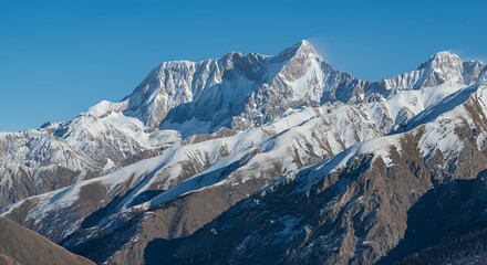 Majestic Snow-Capped Mountains in the Caucasus Range under a Clear Blue Sky