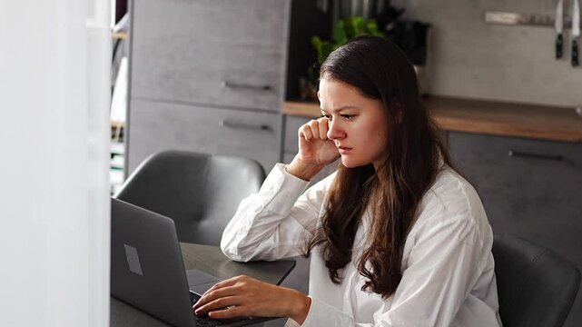 Thoughtful tired woman working on laptop computer looking on screen thinking solving problem at home office, serious woman search for inspiration make decision feel lack of ideas