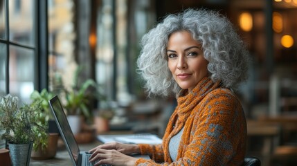 A woman with curly hair working on a laptop in a cozy caf? setting.