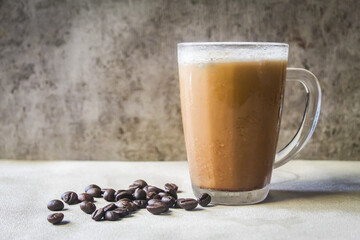 a glass of iced cappuccino coffee with coffee beans