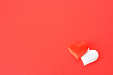 a red heart with a white heart in the corner of red paper copy space