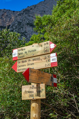 Wanderurlaub auf Sardinien, Italien: Wandern im Osten der Insel bei der berühmten historischen Stätte Tiscali, Wegweiser, Schilder, Richtungsweiser aus Holz