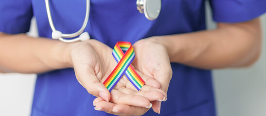 Doctor with LGBTQ Rainbow ribbon for Support Lesbian, Gay, Bisexual, Transgender and Queer community and happy Pride month concept
