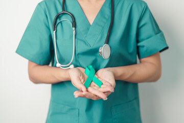 Doctor holding Teal Ribbon for January Cervical Cancer Awareness month. Uterus and Ovaries, Cervix, Endometriosis, Hysterectomy, Uterine fibroids, Reproductive, Healthcare and World cancer day