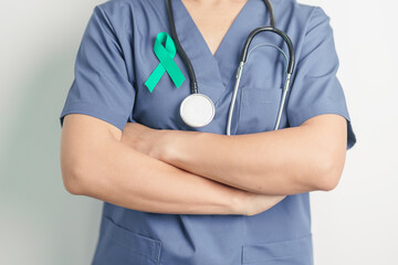Doctor holding Teal Ribbon for January Cervical Cancer Awareness month. Uterus and Ovaries, Cervix, Endometriosis, Hysterectomy, Uterine fibroids, Reproductive, Healthcare and World cancer day