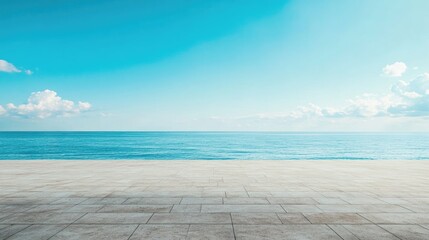 Fototapeta premium Serene ocean view under a vast blue sky with fluffy clouds above an empty concrete surface ideal for promotional banners and tranquil backgrounds.