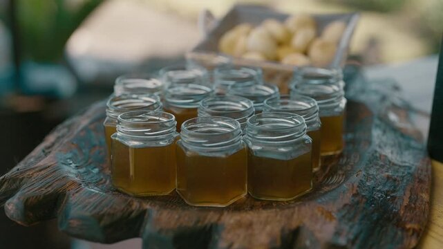 Small glass jars with mate cocido resting on wooden tray and out of focus chipa bread in the background slow motion footage