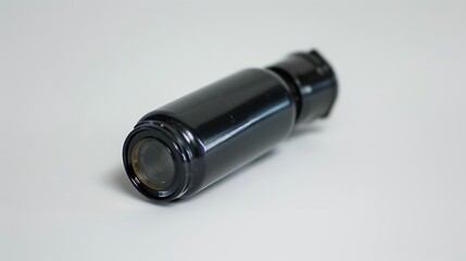 A police-issue pepper spray canister lying flat on a white background.
