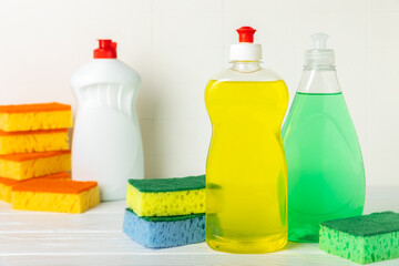 Colorful dish sponges on textured background. Kitchen sponge. Cleaning concept, cleaning service. Dishwashing liquid with clean and dirty dishes plate. Place for text, copy space. Wash the dishes.