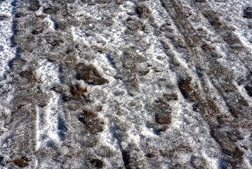 Shoe prints and tracks in the snow.