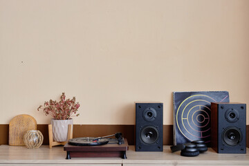 Minimal background image of home audio setup with retro record player speakers and headphones in...