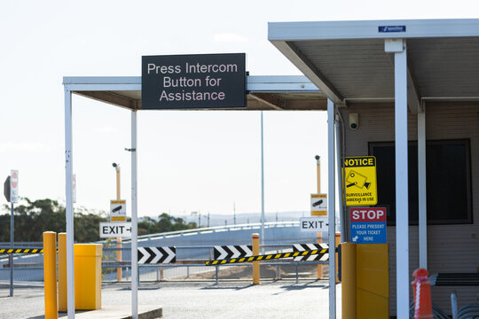 press intercom button for assistance sign above pay for parking booth in city