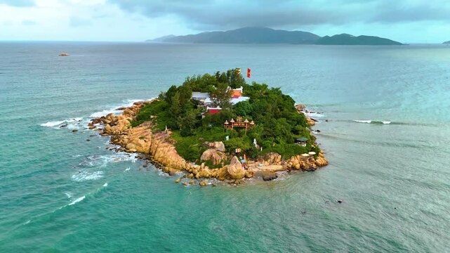 Aerial view, Idyllic islet with traditional structures amidst Chua Tu Ton rocky outcrops off Nha Trang coast Hon Do.