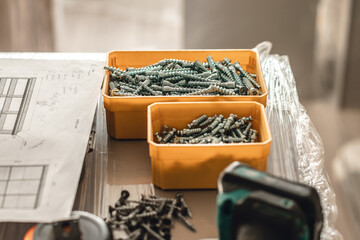 Screw nails lying in a box on a work table during home renovation