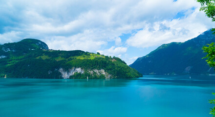 A picturesque scene depicting vivid blue waters embraced by lush green hills creating a dynamic and...