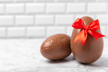 Easter chocolate egg on textured background. Easter celebration concept. Easter chocolate rabbit. Chocolate sweet eggs. Candies on textured wooden table. Space for text.Copy space. Gift. Banner.