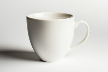 Obraz premium Classic white coffee mug with smooth ceramic finish and ergonomic handle isolated on a white background, ideal for hot beverages and custom branding