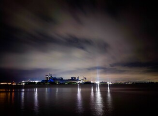 long exposure of a riverscape at evening when bluish sky was colorful and city lights are turning on beside the big river.
