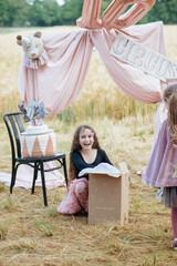 Naklejka premium little girl opens her birthday present, astonishment and happiness. Birthday party.