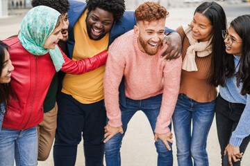 Multiracial young people having fun outdoor laughing together - Diversity and city lifestyle concept during winter season - Main focus on red hair man face