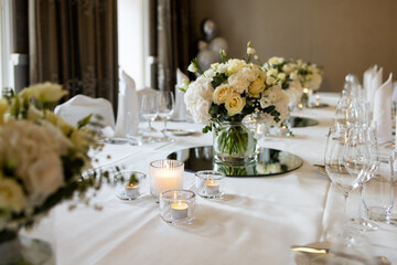 Fototapeta premium Candles, flowers in the table setting for a banquet in a restaurant