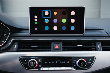 Obraz premium Modern brown car interior, leather steering wheel, climate control, navigation, air ducts, deflectors on the car panel, interior details.