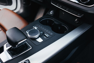 Modern brown car interior, leather steering wheel, climate control, navigation, air ducts, deflectors on the car panel, interior details.