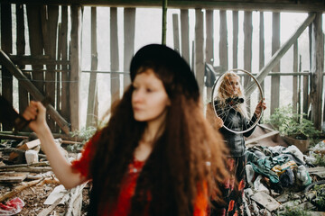 Two Women in Rustic Barn Holding Saw and Wheel