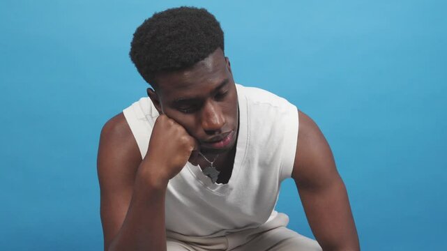 Young man showing boredom resting his face on his hand