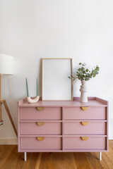 Modern living room interior featuring stylish pink dresser and home decor