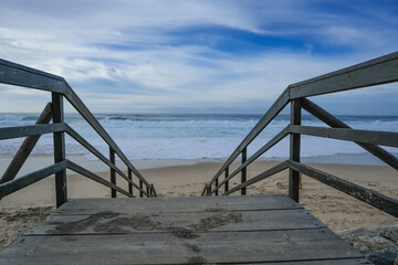 A wooden boardwalk leads to the beach