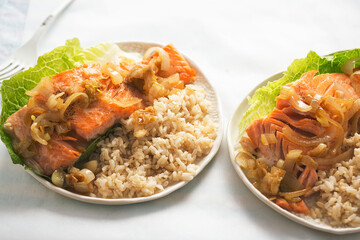 Salmon in shallot ginger soy sauce with brown rice served on romaine lettuce 