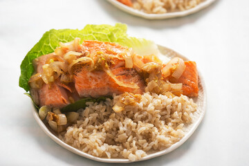 Salmon in shallot ginger soy sauce with brown rice served on romaine lettuce 