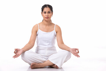 Studio shot of a young fit woman doing yoga exercises white background,