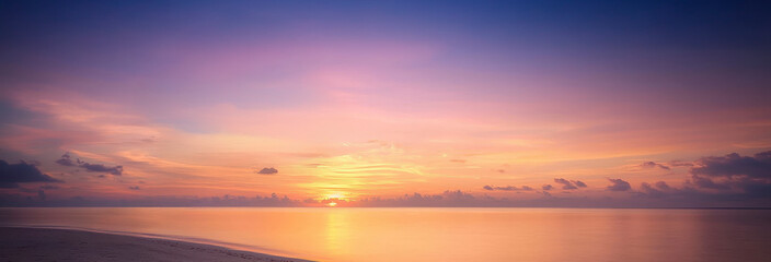 Fototapeta premium A serene sunset over calm waters, showcasing vibrant colors of orange, pink, and purple blending beautifully in the sky.