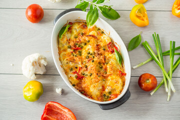 cauliflower baked with sweet pepper and vegetables under cheese