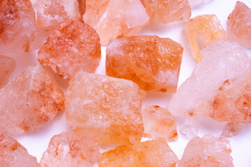 A pile of pink rocks on a white background. The rocks are of different sizes and shapes, and they appear to be arranged in a random pattern. 
