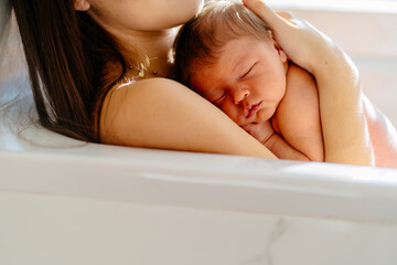 Obraz premium Peaceful sleeping newborn baby cradled in mother's arms