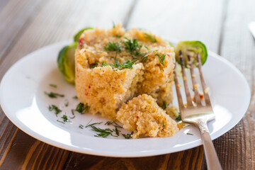 homemade cooked bulgur with Brussel sprouts in a plate, on a wooden table