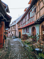 Obraz premium Eguisheim - Charming, colorful, snowy cobblestone street with half-timbered houses in snow and colorful facades, France's most beautiful village, Alsace region, France Travel destination in November