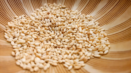 Close up shot of Roasted white sesame seeds in Japanese mortar grinding bowl ready to serve, Japanese menu, aromatic nuts and seeds, coating ingredient flavor