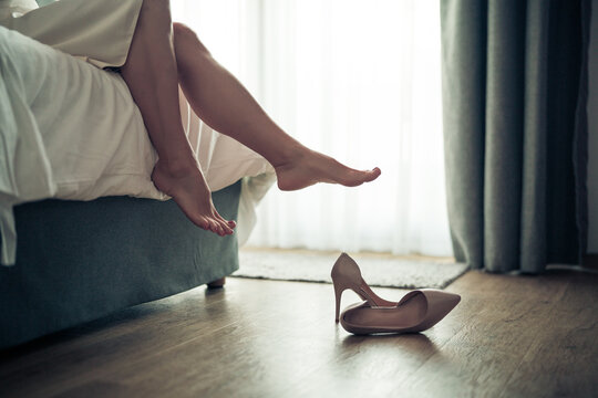 Womans feet in white bathrobe lying on sofa and relaxing at the room