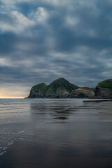 Moody sunset atmosphere at the Te Henga surf beach, Auckland, New Zealand