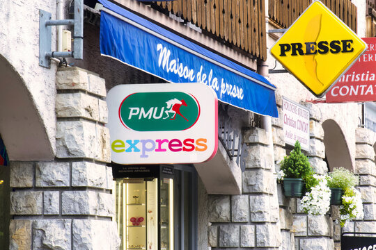 thones, france - 03 September 2022:the sign of PMU, the french gambling company is hanging above an historic village newspaper store