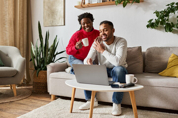 Obraz premium A loving couple enjoys quality time together, laughing and sipping coffee as they relax at home near laptop