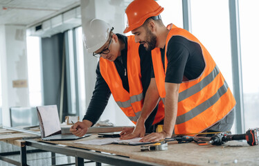 In the unfinished room together. Two construction workers
