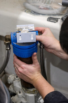 Replacement of a water softener filter cartridge by a technician, in a house.