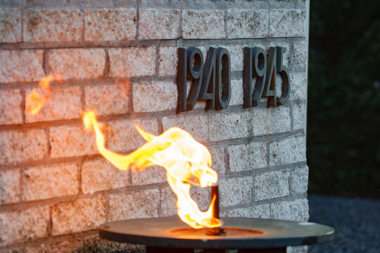 Eternal flame honors memories of a significant historical period marked by resilience and courage from 1940 to 1945 in a tranquil outdoor setting
