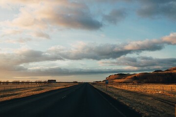 Long road under dramatic sky at golden hour